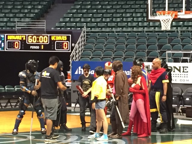 Superheroes assembled prior to warmups between Hawaii and UC Davis.